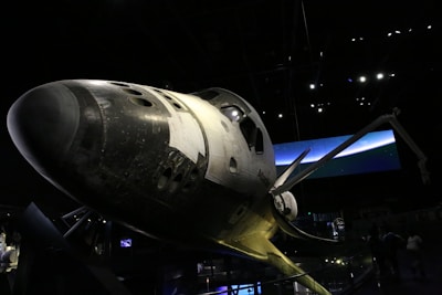 A spacecraft is on display in the dark.